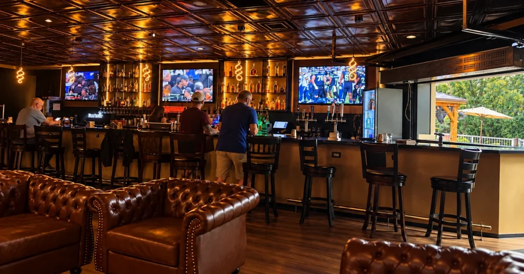Three televisions showing football above the bar at Jallo cigar lounge.